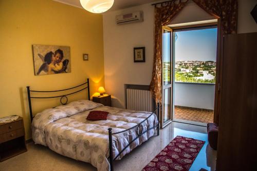 卡斯特拉纳格罗泰玛丽安吉住宿加早餐旅馆的一间卧室设有一张床和一个大窗户