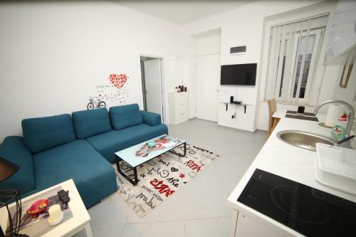 贝尔格莱德月神公寓的一间带蓝色沙发的客厅和一间厨房