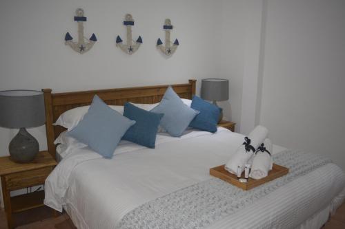 阿曼济姆托蒂Beach Retreat Guesthouse的一间卧室配有一张带蓝色和白色枕头的床