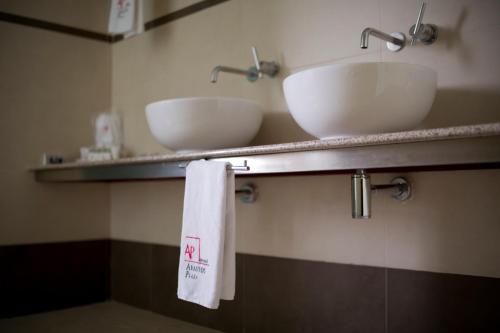 墨西哥城阿巴斯托斯广场酒店的浴室设有2个水槽和2条架子上的毛巾