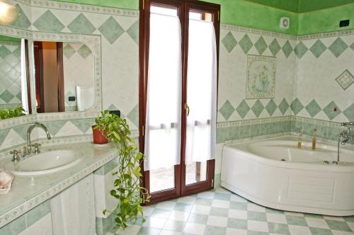 博萨Casa vacanze Sandalia的浴室设有2个水槽、浴缸和镜子