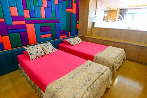 佛丕七岩海滩俱乐部公寓的色彩缤纷的墙壁内的两张床