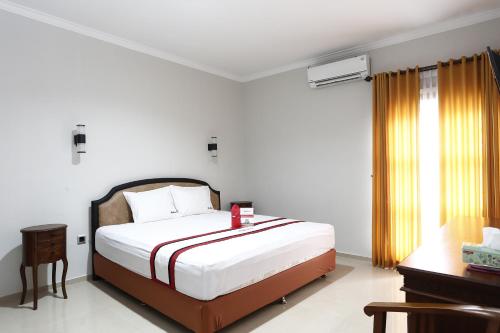 日惹RedDoorz Plus near Adisucipto Airport 2的一间卧室设有一张大床和一个窗户。