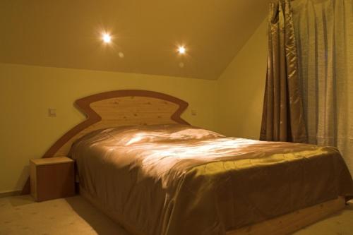 锡纳亚Pensiunea Turistica Delmonte Holiday的一间卧室配有一张带木制床头板的床