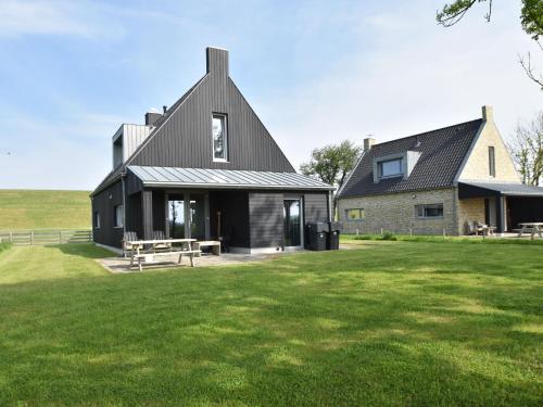 曲马勒姆Detached villa on the Zeedijk with view的一座黑屋顶和草地庭院的房子