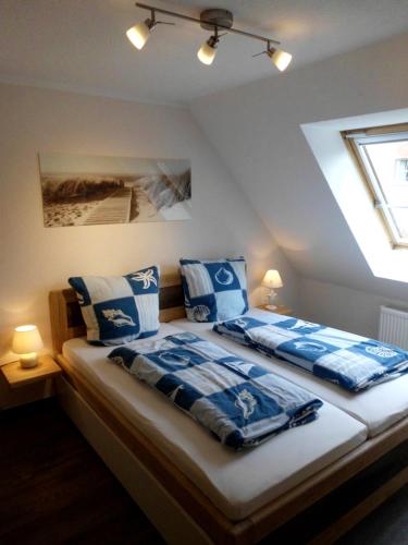 罗斯托克Pension Ostseeurlaub的一间卧室配有两张带蓝白色枕头的床