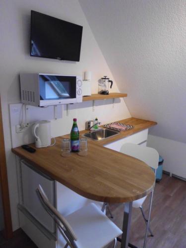 罗斯托克Pension Ostseeurlaub的一个带桌子和水槽的小厨房