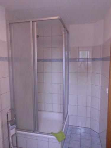 罗斯托克Pension Ostseeurlaub的浴室里设有玻璃门淋浴