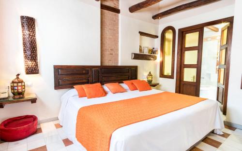 格拉纳达Casa de Federico Boutique的一间卧室配有一张带橙色枕头的大床