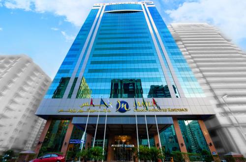 阿布扎比Grand Mercure Abu Dhabi的一座高大的蓝色建筑,上面有标志