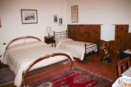 阿雷佐昂提卡薛达迪拿住宿加早餐旅馆的一间带两张床的卧室和地毯