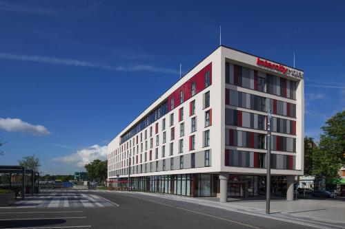 杜伊斯堡杜伊斯堡城际酒店的街道上一座白色的大建筑,设有红色窗户