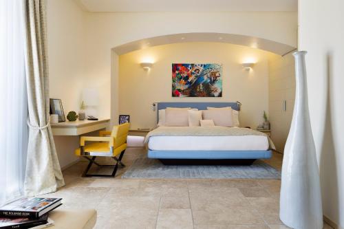 阿纳卡普里Hotel Villa Blu Capri的一间卧室配有一张大床和一张黄色椅子