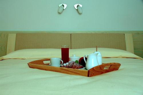 努奥罗La Casa di Boz B&B的床上的盘子,上面有杯子
