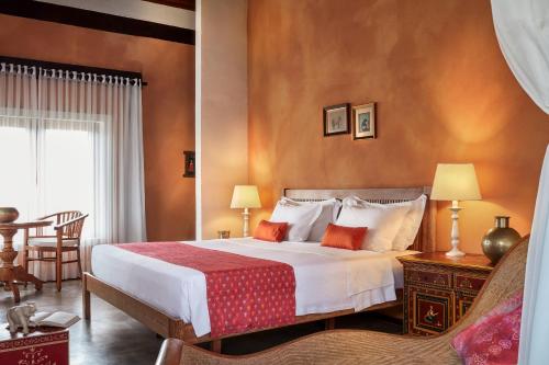 特赖里琐拉海滩酒店 的一间卧室配有一张床和一张桌子及椅子