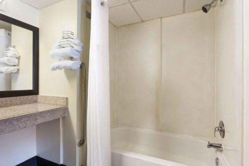 奥古斯塔Heritage Inn Augusta的带淋浴和毛巾浴缸的浴室