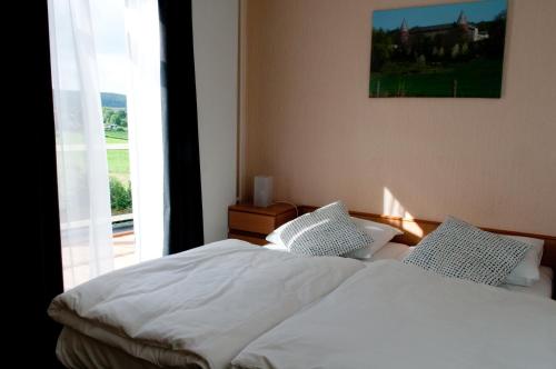 费伦非勒尔豪夫酒店餐厅的一间卧室配有一张带白色床单的床和一扇窗户。
