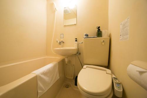 大分910酒店的浴室配有卫生间、盥洗盆和浴缸。