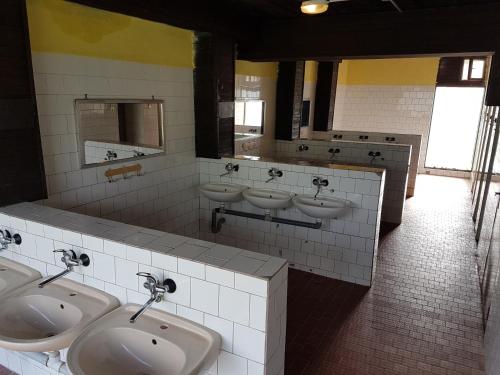 塔查斯卡-鲁穆尼卡塔查尼克国际露营酒店的浴室设有3个水槽和3个小便池