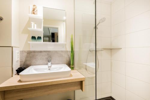 埃姆登Hotel DH -Deutsches Haus-的一间带水槽和淋浴的浴室