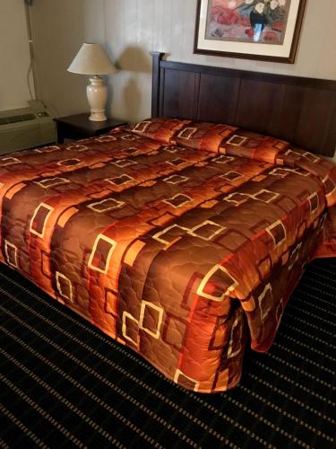 拉伯克Hub City Inn的一张位于酒店客房的床铺,床上有毯子