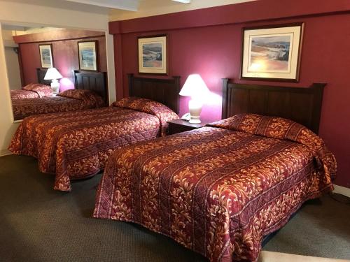拉伯克Hub City Inn的红色墙壁的酒店客房内的两张床