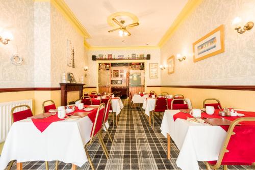 布莱克浦瓦尔丁住宿加早餐旅馆的餐厅设有红色和白色的桌椅