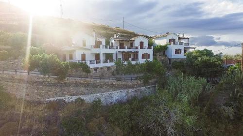 埃夫迪洛斯Ikaria Utopia - Cusco Studios的山上有太阳的大白色房子