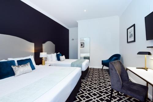 悉尼High Cross Randwick by Sydney Lodges的酒店客房配有两张床和一张书桌