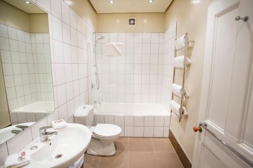 惠灵顿露台别墅服务式公寓的白色的浴室设有水槽和卫生间。