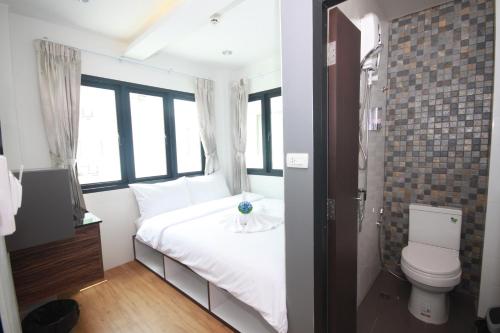 曼谷达林旅舍的卧室配有白色的床和卫生间