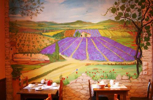 迪涅莱班Hotel De Provence的墙上一幅画,画着两张桌子