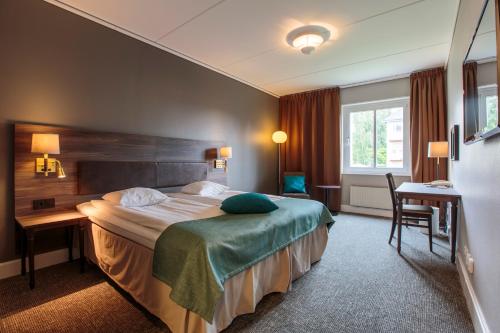 于默奥克拉利奥乌曼连锁酒店的配有一张床和一张书桌的酒店客房