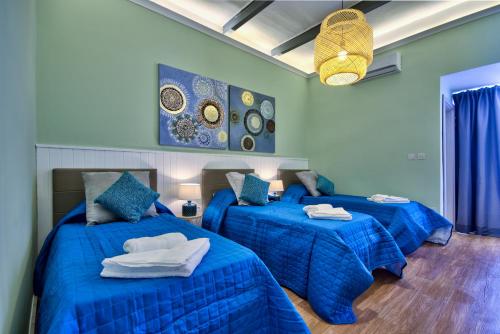 斯利马Amazing 4-bedroom Sliema Town House with Jacuzzi的一间卧室配有两张带蓝色棉被的床