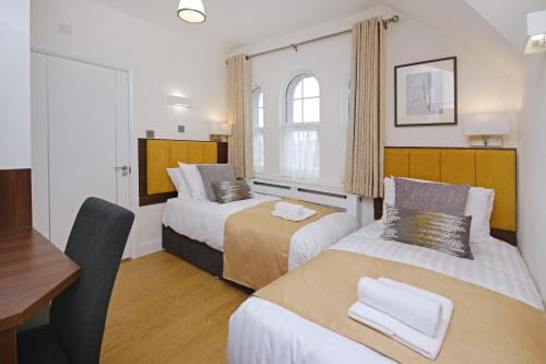 豪士罗帝国宾馆有限公司酒店的酒店客房配有两张床和一张书桌