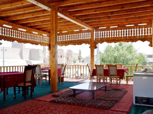 希瓦Khiva Alibek B&B & Travel的庭院内带桌椅的木制凉亭