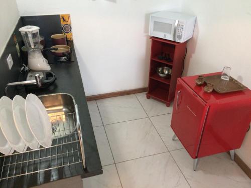 马利西亚斯Suites Vida Mansa的一间带红色冰箱和微波炉的小厨房