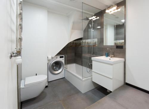 尤尔马拉尤尔马拉威布杜丽公寓的浴室配有洗衣机、洗衣机和烘干机。