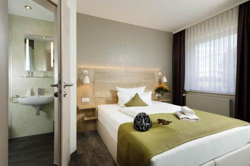 巴德马斯考Am Schloßbrunnen Bad Muskau的酒店客房设有带水槽和水槽的床。