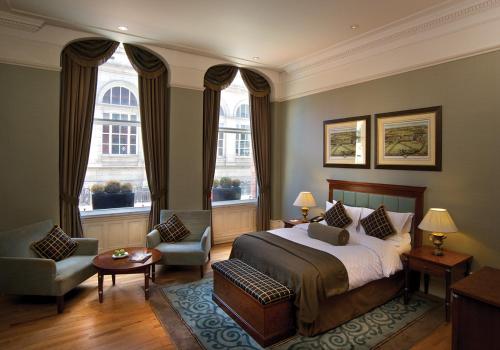 利兹魁北克酒店的一间卧室配有一张床和一把椅子,还有两个窗户