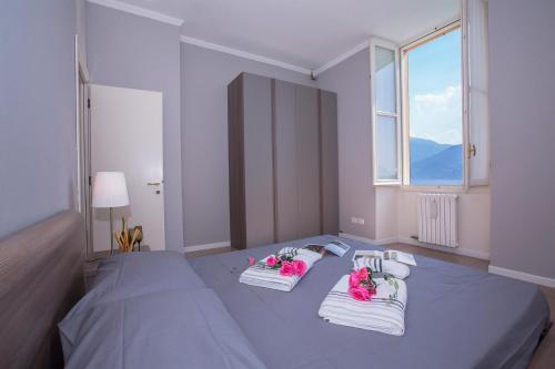 梅纳焦Casa Daniele的一间卧室配有蓝色的床,床上有粉红色的鲜花