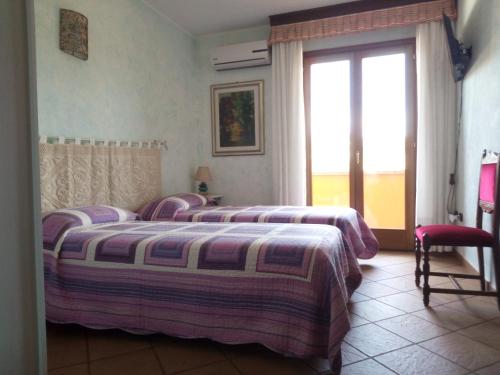 OssiGrotta Delle Fate的一间卧室设有两张床和大窗户
