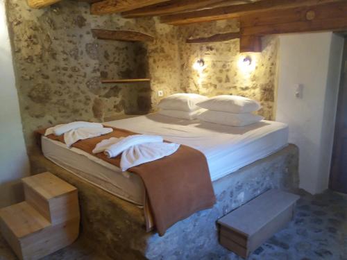SpílionHeracles Traditional Cretan Houses的卧室配有一张带白色床单和枕头的大床。