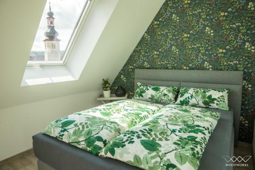 吕德斯海姆TeigenHeim的一间卧室配有一张带绿色床罩的床和窗户。