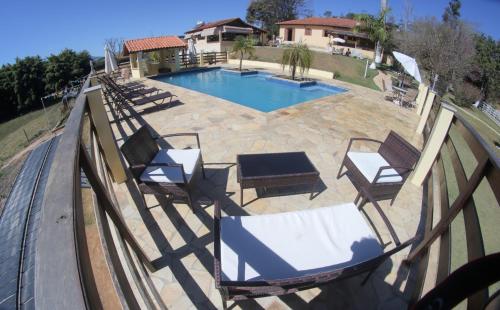São Sebastião do Rio Verde圣塞巴斯蒂昂旅馆的一个带椅子和围栏的游泳池