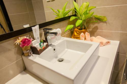 马六甲阿姆斯顿遗产度假村的浴室里装有鲜花的白色水槽