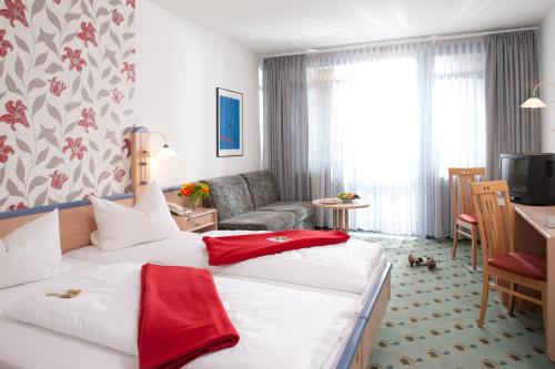 格斯韦因斯泰因百灵达休闲和商务酒店的酒店客房设有一张大床和一间客厅。