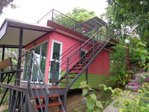 哈林海滩Hill Zone Home Stay by Little Paradise的一座红色和绿色的房子,设有楼梯
