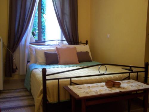 斯特姆尼察Diavatiko的一间卧室配有一张床、一张桌子和一个窗户。