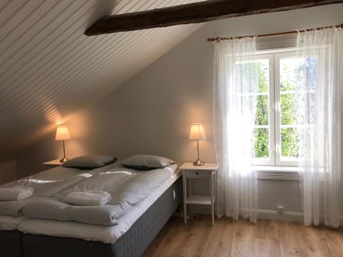 Nivelax巴卡斯高尔夫及乡村俱乐部酒店的一间卧室配有一张带两盏灯的床和一扇窗户。
